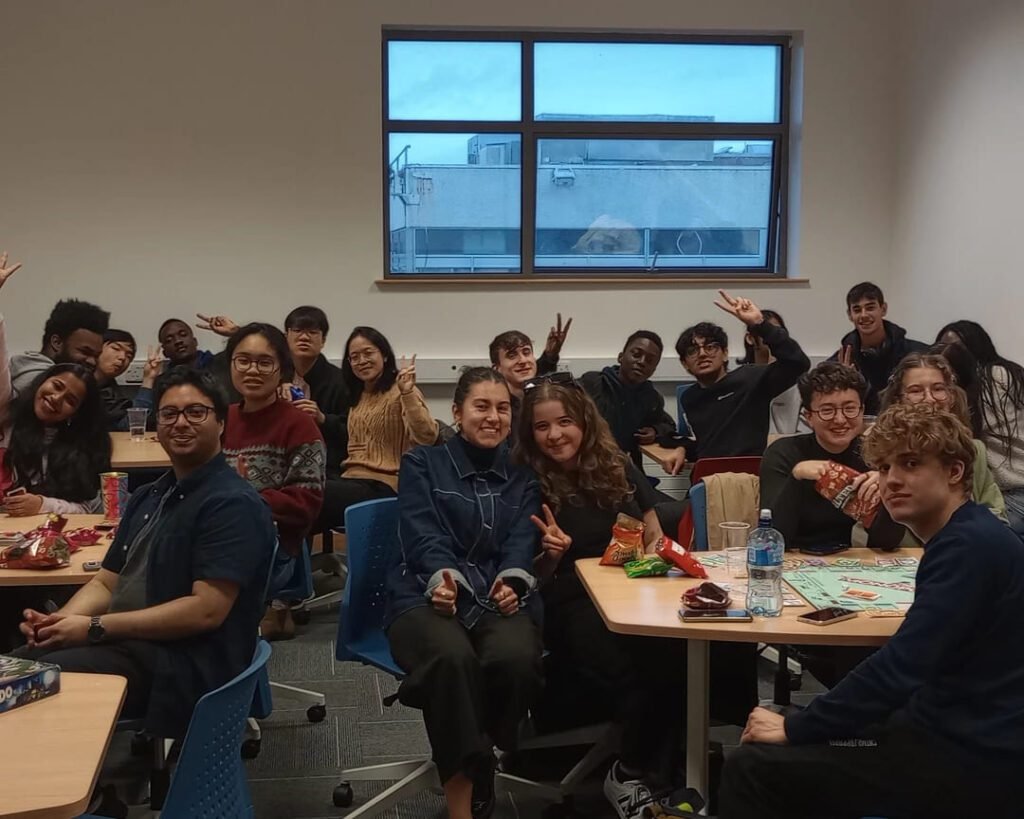 International Student Society members gathered for a social event in a classroom, engaging and interacting with each other.