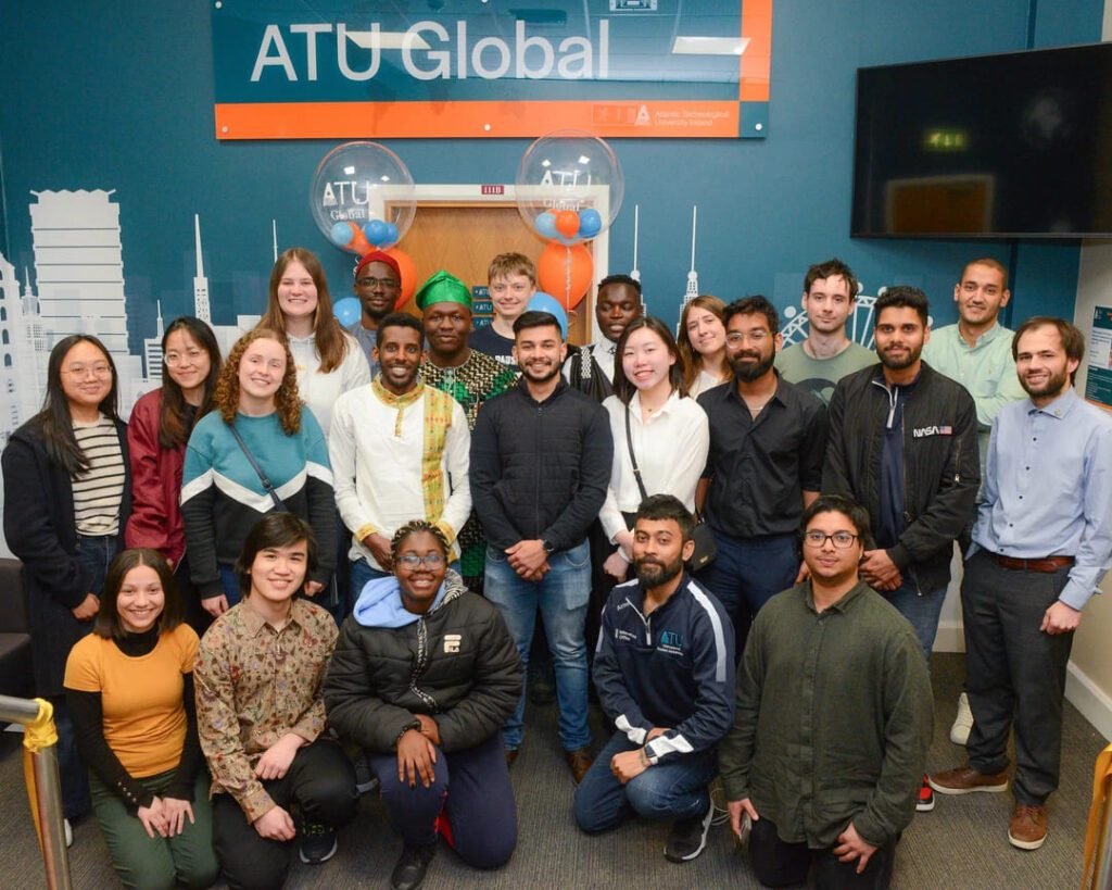 Diverse group of International Student Society members at the ATU Global welcome event, smiling and posing in the event hall.